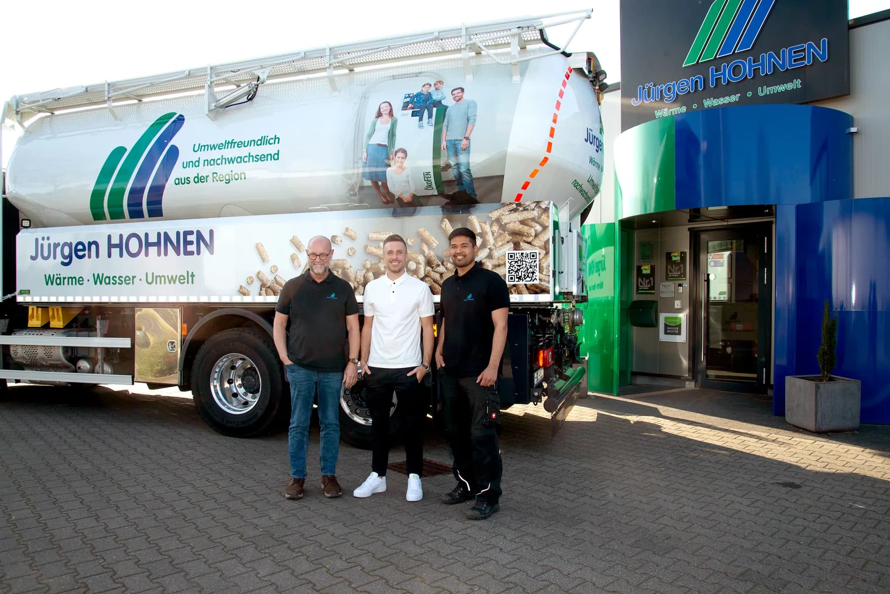 Das Team der Jürgen Hohnen GmbH mit Selmir Suljkanovic vor dem Pellet-Lkw und dem Firmengebäude